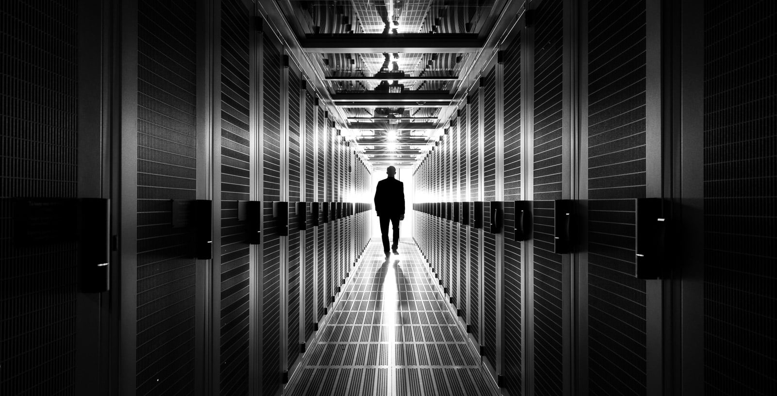 man walking in aisle of data centre