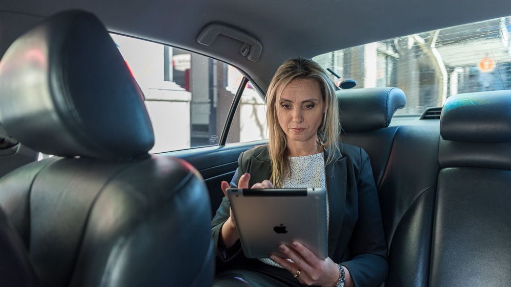 mobile on-location photography - woman in taxi checking iPad