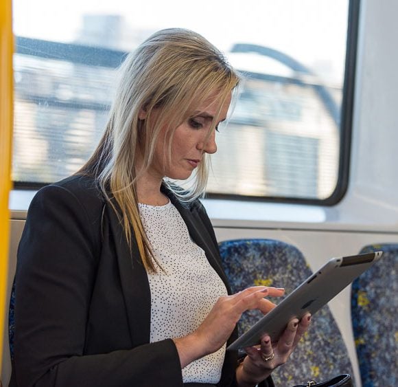 On an on-location portrait of a woman checking iPad on train