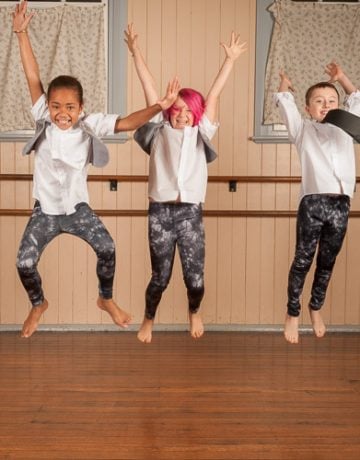 three children jumping during a school dance